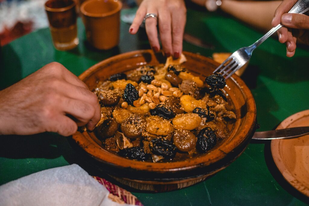Traditional Moroccan chicken tajine with preserved lemons and green olives served in a clay pot.